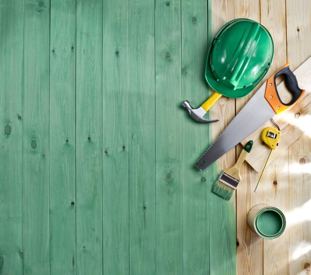 Green wood floor with a brush, paint, tools and helmet